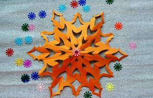 Hermoso copo de nieve de papel con las manos