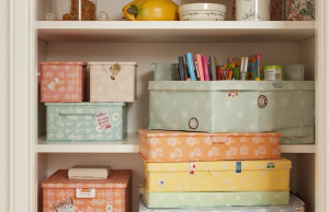 📦 Как да си направим трайни кутии за съхранение от картон: трикове от практиката Цветни подсилени картонени кутии за съхранение, подредени на купчина в складовото помещение