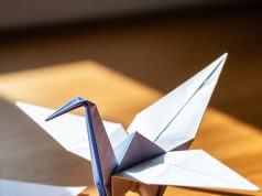 🦢 Как сделать оригами-журавлика: Классический мастер-класс для начинающих Готовый классический оригами-журавлик, стоящий на столе.