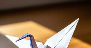 🦢 Как сделать оригами-журавлика: Классический мастер-класс для начинающих Готовый классический оригами-журавлик, стоящий на столе.