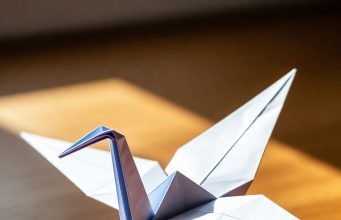 🦢 Как сделать оригами-журавлика: Классический мастер-класс для начинающих Готовый классический оригами-журавлик, стоящий на столе.